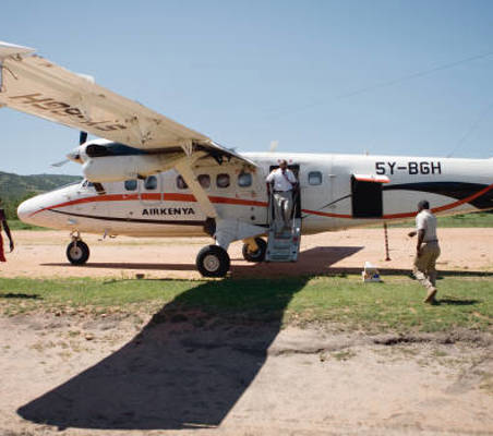 Air Kenya flying safaris maasai loads luggage on plane ®bushtreksafaris