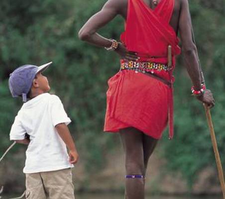 maasai warrior looks down to talk to small boy ®bushtreksafaris